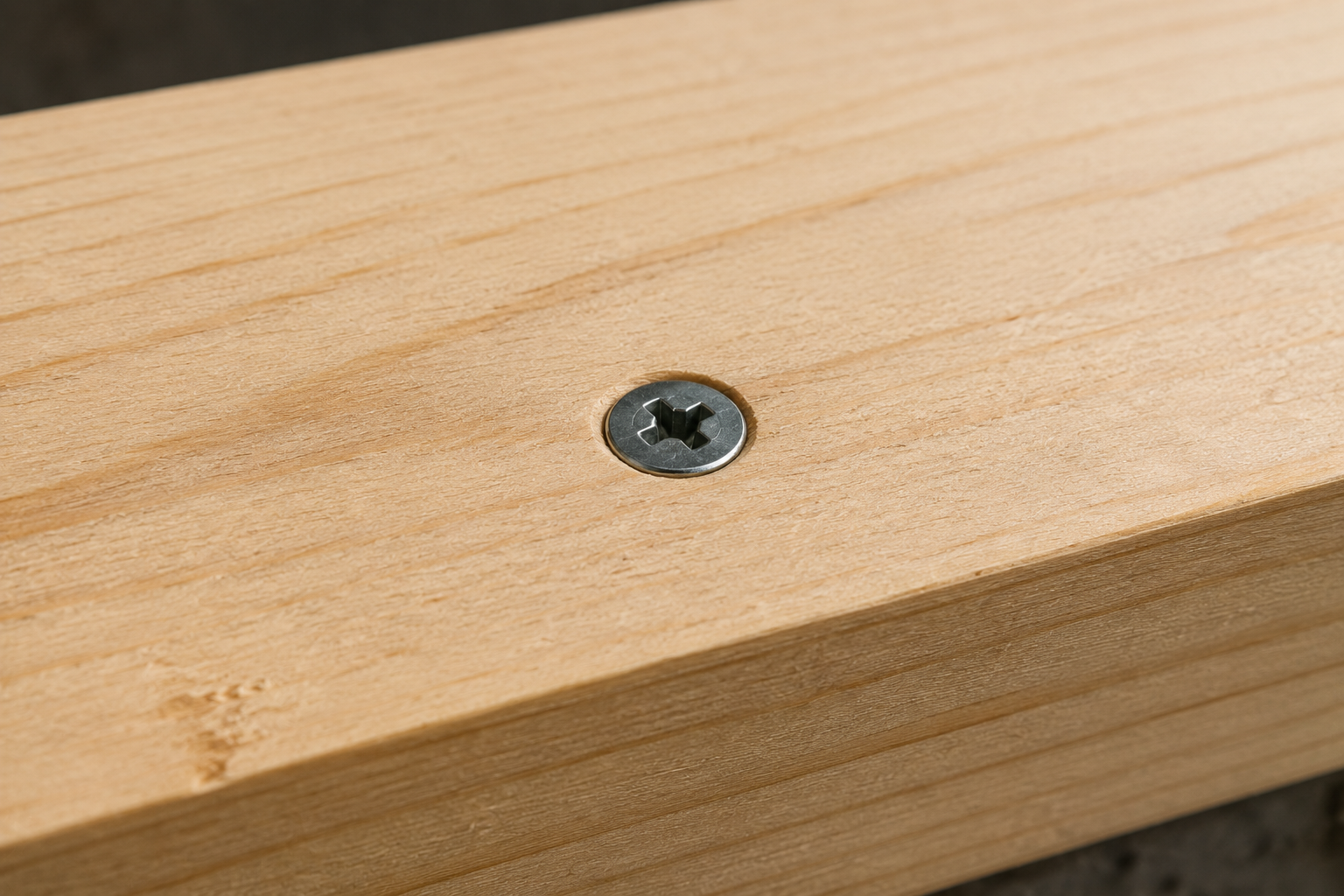 Phillips flat-head screw installed flush with the surface of a wooden board